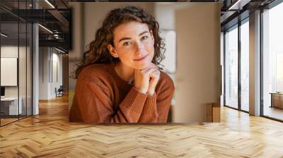 Serene young woman looking at camera Wall mural