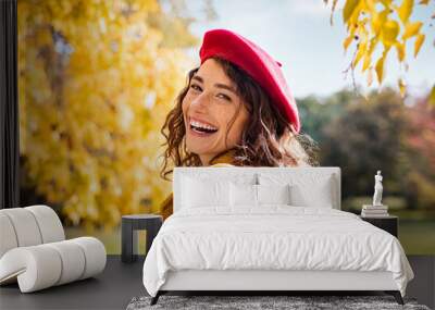 Smiling happy woman looking behind in an autumn day Wall mural