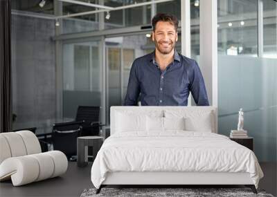 Successful business man looking at camera in office Wall mural