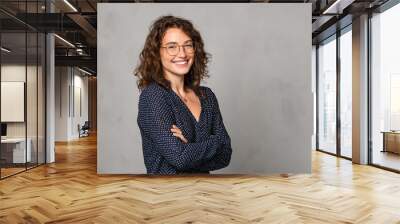 Successful smiling woman wearing eyeglasses on grey wall Wall mural