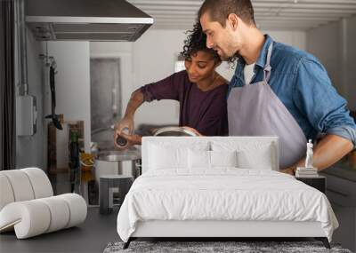 Woman adding salt in pot while cooking Wall mural