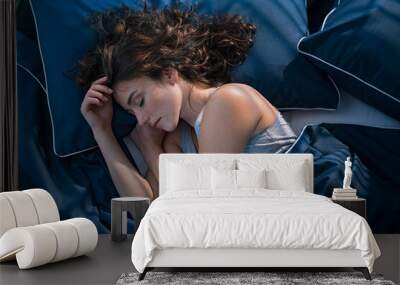 Young woman sleeping in bed at night Wall mural