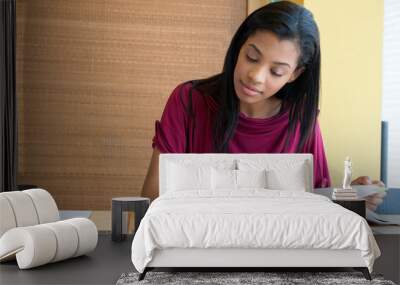 Young woman studying in the library Wall mural