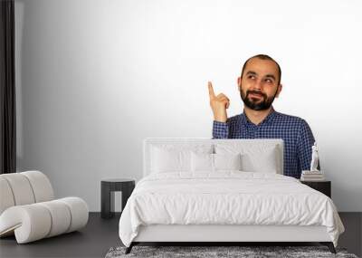 Young Turkish man has an idea gesture, pointing with finger and looking up on isolated white background. Thoughtful guy solved a problem problem. Face expression, body language. Wall mural