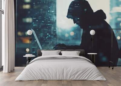 A silhouetted figure in a hoodie works on a laptop, surrounded by digital elements. Wall mural