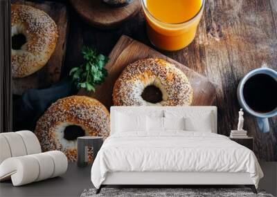 Bagels with fresh cheese and herbs on a breakfast table , with fresh orange juice and coffee on the side Wall mural