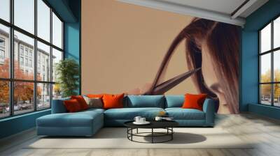 Hairdresser cutting client's hair with scissors on beige background, closeup Wall mural