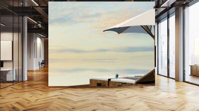 Deck Chairs and umbrella in sunset on the beach Wall mural