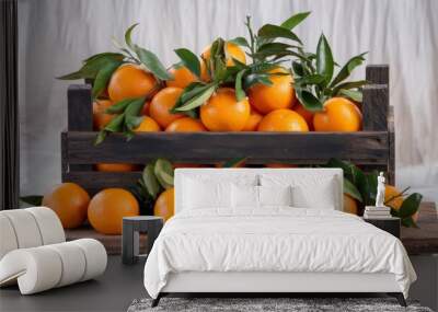 Ripe oranges with leaves in a rustic wooden crate, isolated against a white backdrop Wall mural