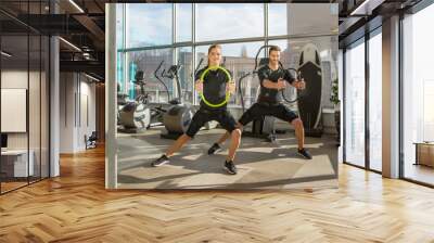 Man and woman doing electro muscular stimulation training in a modern gym Wall mural