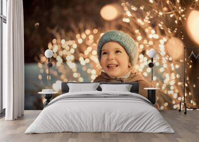 portrait of happy girl in winter evenings on background of Christmas lights Wall mural