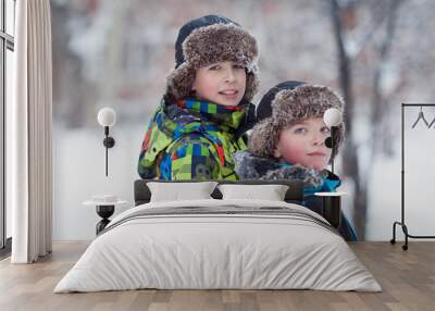 Two cheerful happy boys playing in winter park Wall mural