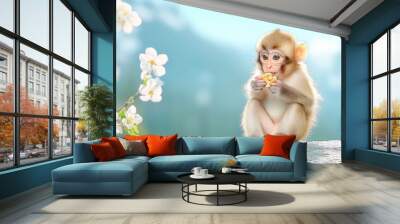 A close-up shot of a monkey sitting on a rock, nibbling on a piece of food with its tiny hands. The serene background features a calm forest, creating a peaceful ambiance. Wall mural