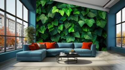 Lush green ivy leaves densely cover a wall, creating a vibrant, natural backdrop. The rich foliage is fresh and full, evoking a sense of tranquility and natural beauty. Wall mural