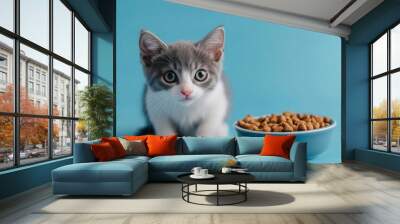 Portrait of cute gray and white cat, sitting near bowl of dry food on blue background, studio shot, Generative AI Wall mural