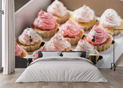 Cupcake packaging, delivery box, vanilla cupcakes with pink and white cream, selective focus, close up Wall mural