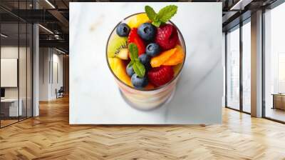 A glass of fruit salad with blueberries, kiwi, and oranges Wall mural