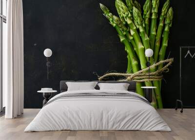 Fresh stems of green asparagus on dark background. Vegan, healthy eating, dieting concept. Organic vegetables. Wall mural