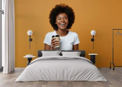 Happy woman with coffee cup against yellow background Wall mural