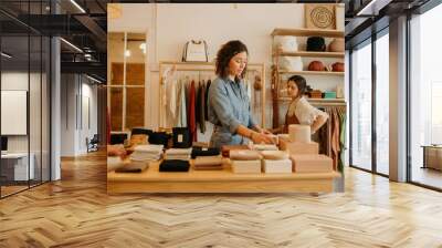 Two women shopping in a store with clothing and home goods Wall mural