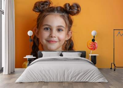 A young girl is holding a lollipop and smiling Wall mural