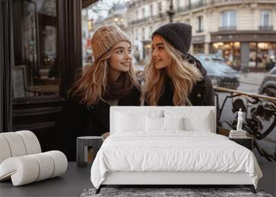 Two women sitting at a table with cups of coffee and pastries Wall mural