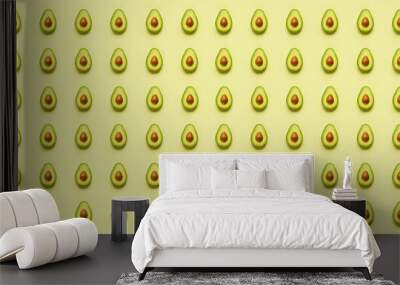 Seamless pattern of fresh ripe avocado halves on a yellow background. Wall mural