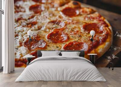 A close-up of a pepperoni pizza with melted cheese and herbs on a wooden surface. Wall mural