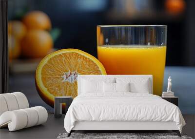 A refreshing glass of orange juice with a halved orange beside it. Wall mural