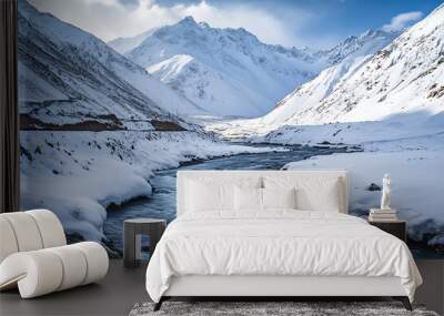 A serene winter landscape featuring snow-capped mountains and a flowing river. Wall mural