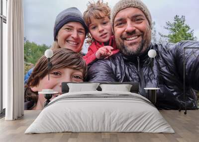 A happy family is relaxing and taking selfie in the mountain Wall mural