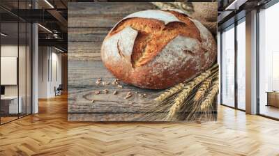 freshly baked homemade sourdough bread with crispy crust and ears of rye and wheat on an old wooden background with place for text modern bakery concept top view healthy natural food Wall mural