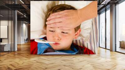 Sick child being checked for fever Wall mural