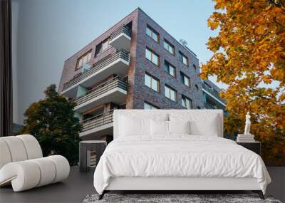 brick apartment building framed by yellow tree Wall mural