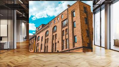 industrial brick building complex with white clouds in the background Wall mural