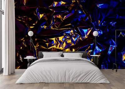 Abstract yellow and blue aluminum wrinkled foil background texture reflecting red and blue light Wall mural