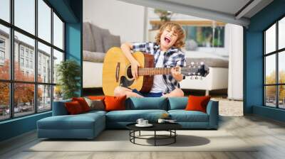 Boy having fun making music with guitar Wall mural