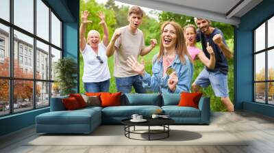 Cheering team and young woman with winner medal Wall mural