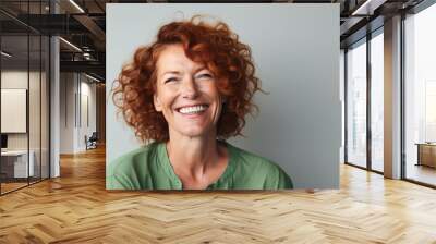 Delighted Irish woman in 40s, red curls, green shirt Wall mural