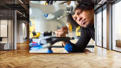 Engineer inspecting gripper arm of a robot in a modern robotics lab Wall mural