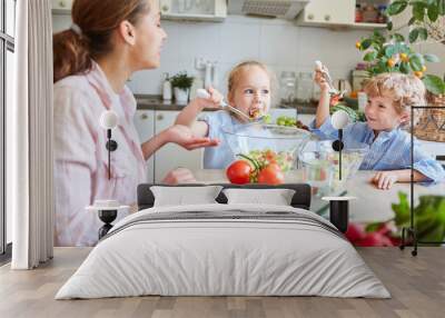 Family having fun while eating vegetable salad at home Wall mural