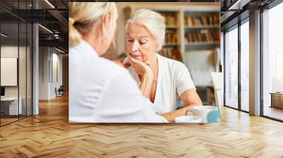 Female doctor cares in depressive elderly woman Wall mural