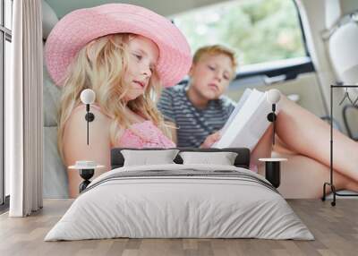 Girl in the car reads a thrilling book Wall mural