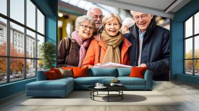 Group of happy senior people in train station looking at map Wall mural