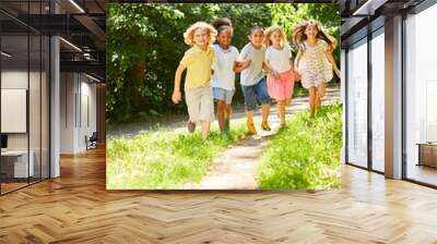 Group of kids running together over meadow Wall mural