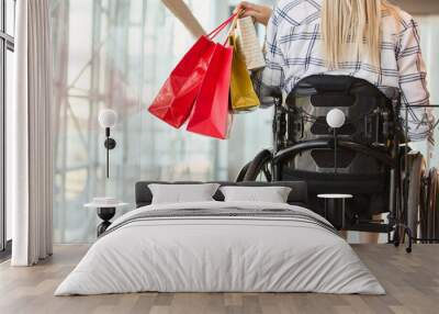 Independent shopping experience of a young woman using a wheelchair at a modern mall Wall mural