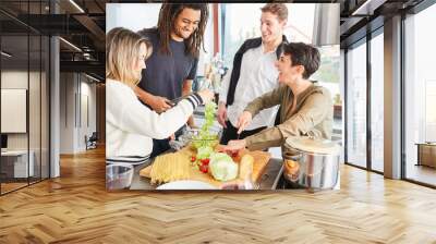 Laughing students prepare salad together in shared kitchen Wall mural