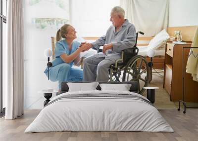 Nurse holding hand of elderly man in wheelchair at rehab center Wall mural