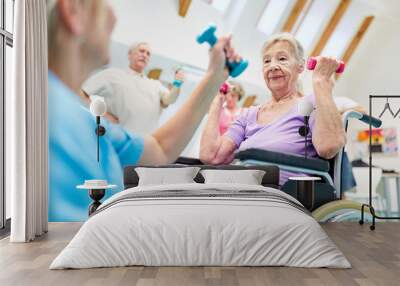 Senior woman in wheelchair doing workout with dumbbells Wall mural