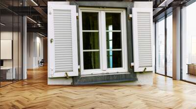 Metal framed window with wood shutters and with white wall Wall mural